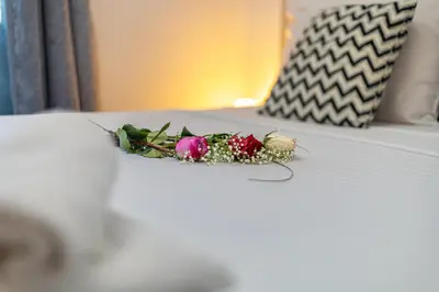 a bouquet of flowers sitting on a bed at Koum Kapi Studio B1 in Chania Town