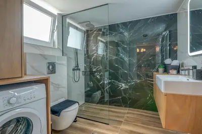 a bathroom with a sink and a washing machine at Villenia Luxury Apartments in Kissamos