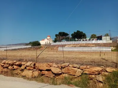 a fence next to a stone wall and a building at Vine Veranda in Palaiochóra