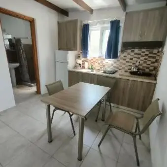 a kitchen with a wooden table and chairs in it at Vine Veranda in Palaiochóra