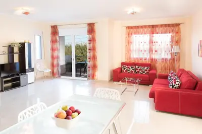 a living room with red furniture and a red couch at Kronos Villas in Kolymvari
