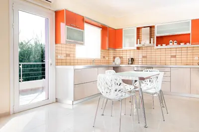 a kitchen with a table and chairs and a window at Kronos Villas in Kolymvari