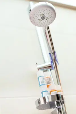 a shower head with several bottles of toothpaste at Kronos Villas in Kolymvari