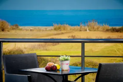 a table with fruit sitting on top of a balcony at Kronos Villas in Kolymvari