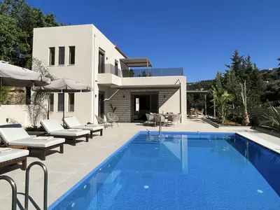 a villa with a swimming pool in front of a house at Villa Karissa in Gavalochori