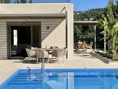 a patio with a table and chairs next to a pool at Villa Karissa in Gavalochori