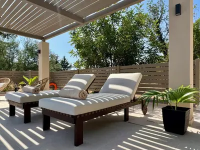 two benches on a patio under a pergola at Villa Karissa in Gavalochori