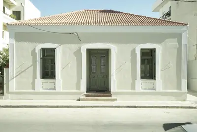 a white house with a green door and two windows at Villa Kalliopi in Chania Town