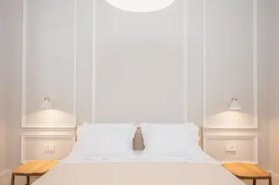 a white bedroom with a white bed with two lights at Villa Kalliopi in Chania Town