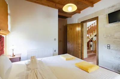 a bedroom with a bed and a tv on the wall at Villas Kalives in Kalyves