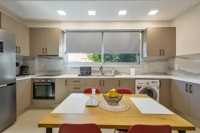 a kitchen with a wooden table with red chairs at Lazareta 3 in Chania Town