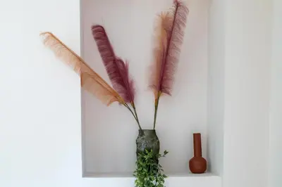 four feathers in a vase on a shelf at Lazareta 3 in Chania Town