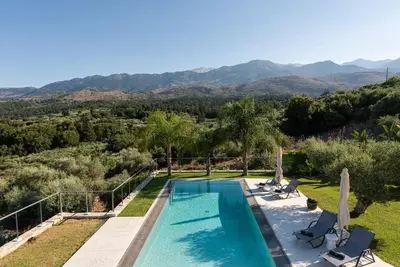 a villa with a swimming pool and mountains in the background at Villa Inati in Nípos