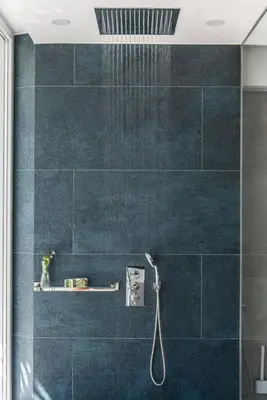 a bathroom with a shower with blue tiles at Villa Inati in Nípos