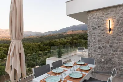 a dining room with a table and views of the mountains at Villa Inati in Nípos