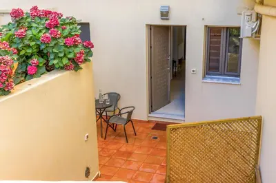 a balcony with a table and flowers on a wall at Dictamus apartment in Chania Town