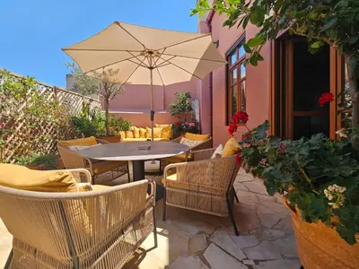 a patio with a table and chairs and an umbrella at Luminous a House of Luxury in Chania Town