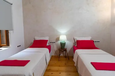 two beds in a room with red pillows at Luminous a House of Luxury in Chania Town