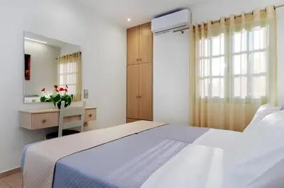a bedroom with a bed and a desk and a window at Argiros House in Chania Town