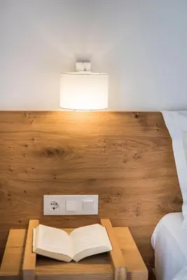 an open book on a wooden table in a bedroom at Glykeria Hotel in Elafonisi