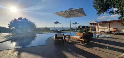 a swimming pool with two chairs and an umbrella at Glykeria Hotel in Elafonisi