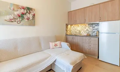 a kitchen with a couch and a refrigerator at Kaiti 's Studios & Apartments in Palaiochóra