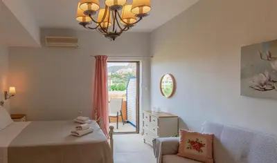 a bedroom with a bed and a chair and a window at Kaiti 's Studios & Apartments in Palaiochóra