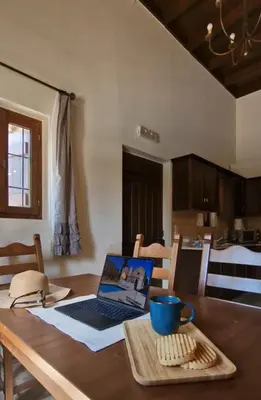 a laptop computer sitting on top of a wooden table at Villa Penelope Luxury Retreat with Pool & Timeless Charm in Douliana