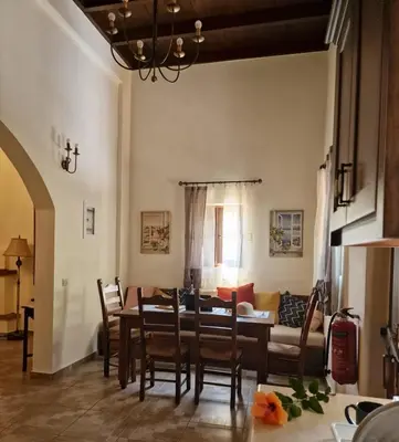 a dining room and living room with a table and chairs at Villa Penelope Luxury Retreat with Pool & Timeless Charm in Douliana