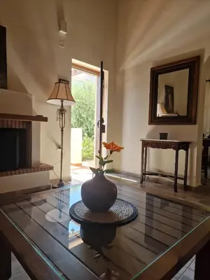 a living room with a vase on a glass table at Villa Penelope Luxury Retreat with Pool & Timeless Charm in Douliana