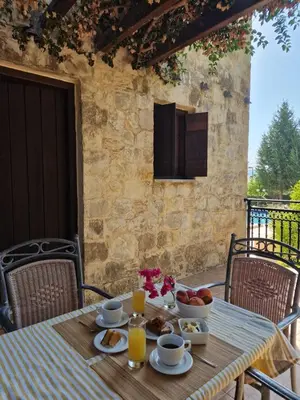 a table with a breakfast of fruit and juice at Villa Penelope Luxury Retreat with Pool & Timeless Charm in Douliana