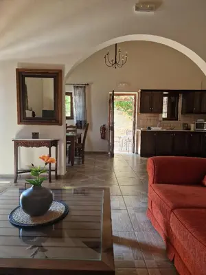 a living room with a red couch and a table at Villa Penelope Luxury Retreat with Pool & Timeless Charm in Douliana