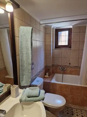 a bathroom with a toilet and a tub and a sink at Villa Penelope Luxury Retreat with Pool & Timeless Charm in Douliana