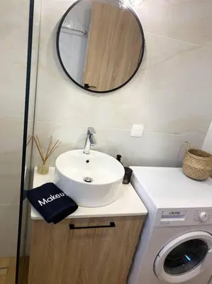 a bathroom with a sink and a washing machine at Thalassa Grammeno seaview house in Palaiochóra