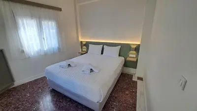 a bedroom with a white bed with towels on it at Downtown Delight in Chania Town