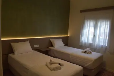 a hotel room with two beds with towels on them at Downtown Delight in Chania Town