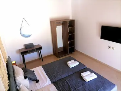 a bedroom with a bed and a desk and a television at VILLA HALEPOURI in Chania Town