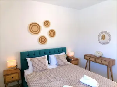 a bedroom with a bed with a blue headboard and two tables at VILLA HALEPOURI in Chania Town