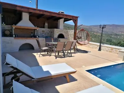 a patio with a table and chairs and a swimming pool at VILLA HALEPOURI in Chania Town