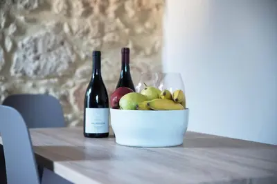 a bowl of apples and two bottles of wine on a table at Myra city House in Chania Town