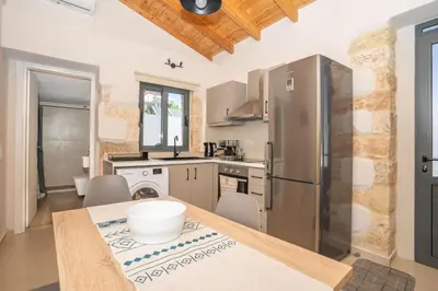 a kitchen with a stainless steel refrigerator and a table at Myra city House in Chania Town