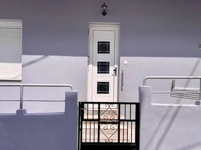 a white house with a white door and a gate at Souda Bay in Souda