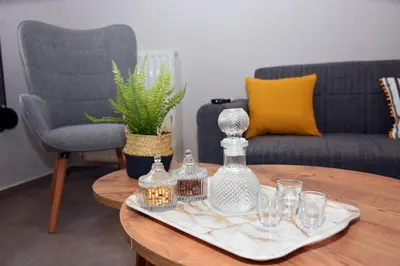 a table with a tray with glass bottles and glasses on it at Manolis cozy home in Chania Town