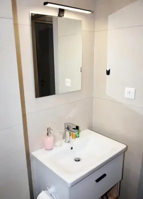 a bathroom with a white sink and a mirror at Manolis cozy home in Chania Town