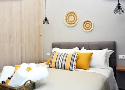 a bedroom with a bed with yellow and white pillows at Manolis cozy home in Chania Town