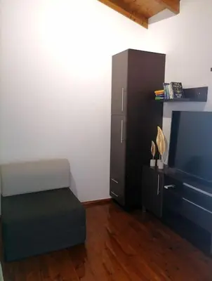 a living room with a chair and a tv at Halepouri Apartment in Chania Town