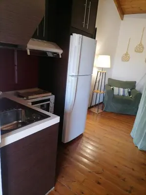 a kitchen with a white refrigerator and a wooden floor at Halepouri Apartment in Chania Town