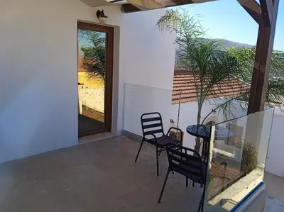 a patio with two chairs and a table and a window at Halepouri Apartment in Chania Town