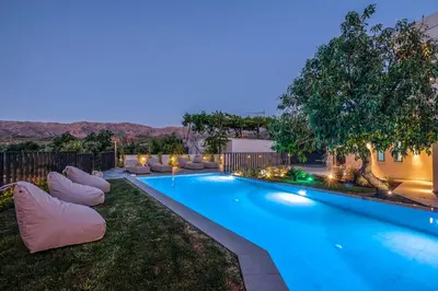 a swimming pool in a yard with chairs around it at Alyona Villas - Villa Lona in Skinés