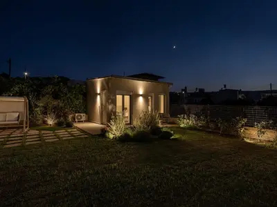 a small house in a yard at night at HappyHouse Villa in Kissamos